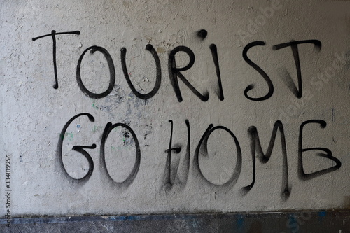 sign saying: tourist go home