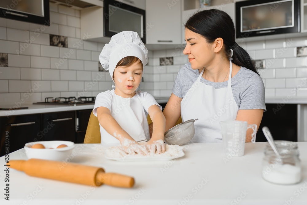 Happy family. Mother teaching her son how to cooking cake menu in morning. healthy lifestyle concept.. Baking Christmas cake and cook concept Happy family. Mother teaching her son how to cooking cake menu in morning. healthy lifestyle concept.. Baking Christmas cake and cook concept