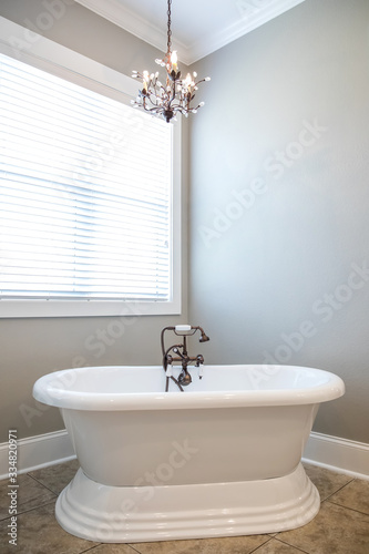 Pure white retro old fashioned vintage new bathtub tub in a new construction bathroom with natural light