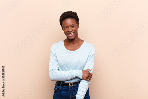 young pretty black womanlaughing shyly and cheerfully, with a friendly and positive but insecure attitude photo