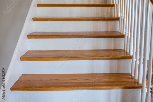 light-colored and white painted hardwood stairs stairway in a modern updated new construction home with a white banister