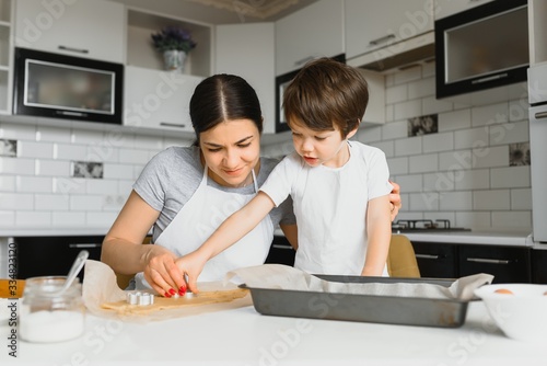 Happy family in the kitchen. Mother and son preparing cookies.