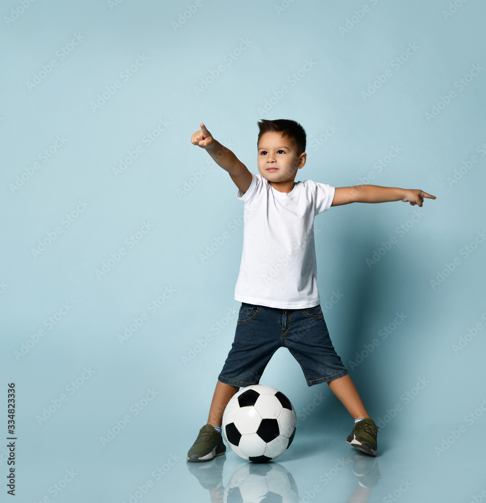 Cute boy playing football, happy child, young male teen goalkeeper