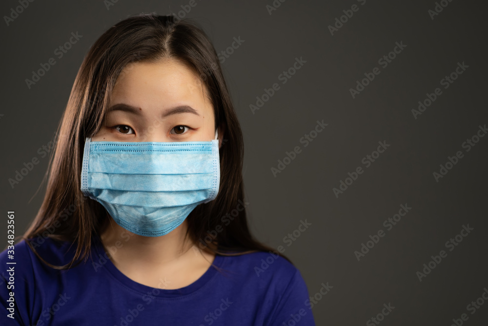 Portrait of asian woman in face protective mask isolated on grey studio background. Copy space, City air pollution, Coronavirus, epidemic 2020, illness concept.