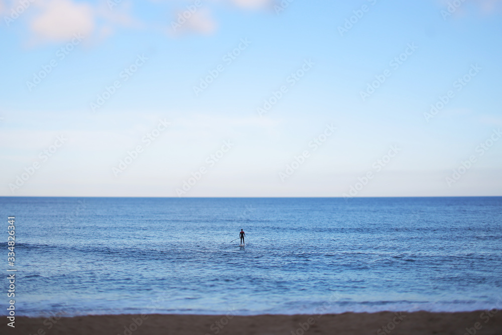 Silhouette of surfer from back on the blackboard in calm sea. Recreation and sports. Barcelona, Spain