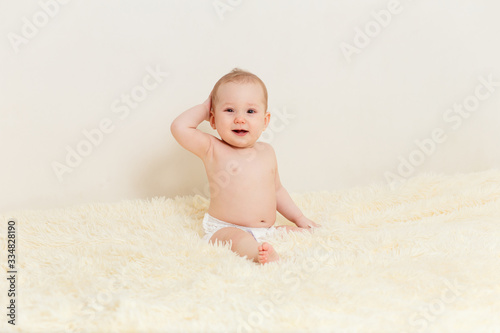 cute baby girl sits well on a fluffy blanket
