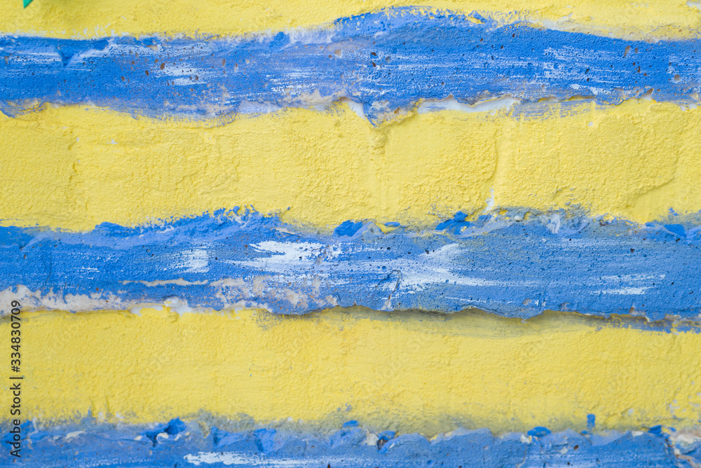 Texture of yellow plaster with a blue stripe. Old wall.