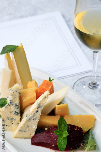 wine set. Assorted cheeses. brie, dor blue, frico, cheddar, picorino, ground pear with almonds. white wine.