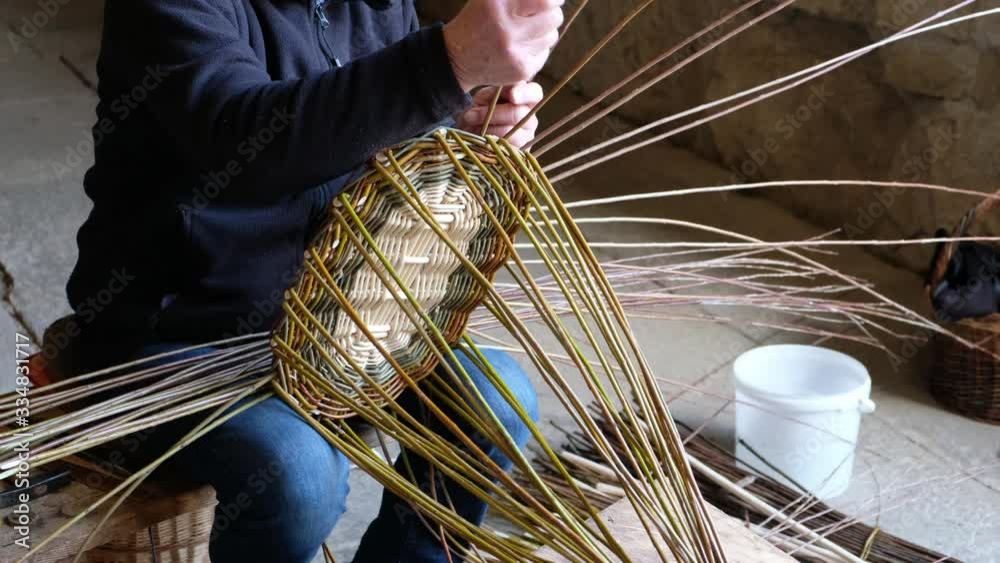 Korbmacher flechtet einen Korb aus Weidenruten