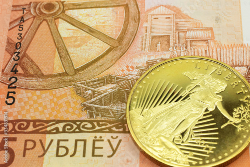 A macro image of a orange five ruble note from Belarus with a gold coin. Shot close up.