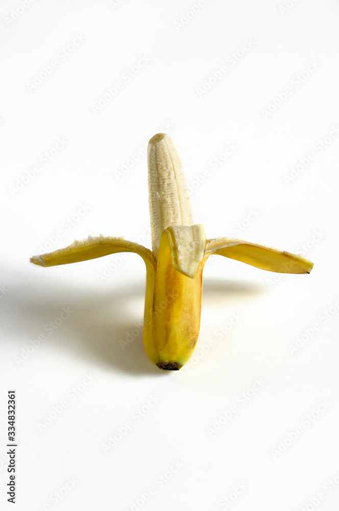 Vertical photograph of a half-peeled banana. Vertical photograph of a half-peeled banana.