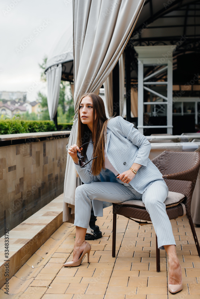 A beautiful young girl is sitting on the veranda of a beautiful house. Relaxation. A beautiful young girl is sitting on the veranda of a beautiful house. Relaxation.