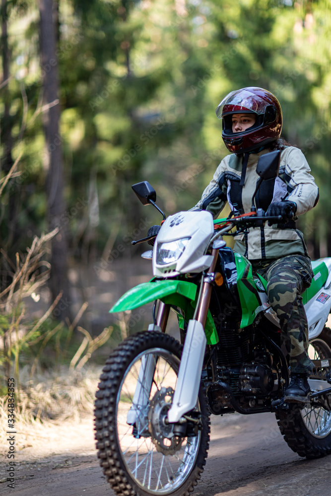 off-road motorcycle trip in the forest, beautiful girl, feminism, sport, brutality, motorcyclist equipment, motorcycle driver, concept, active lifestyle, enduro