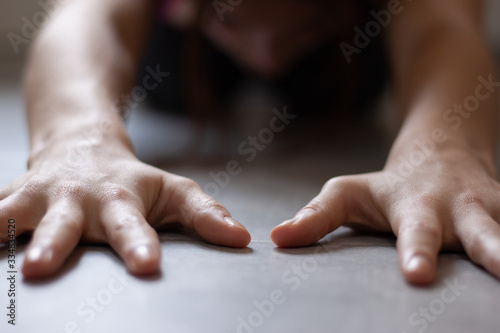 Close up to woman doing childs pose in yoga class in home