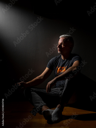 Person sitting and looking optimisticly towards lightsource © Ilari