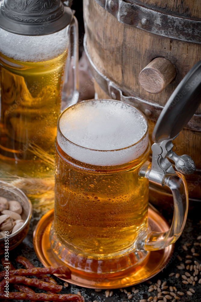 Light frothing beer in a glass, on an old background. Light frothing beer in a glass, on an old background.