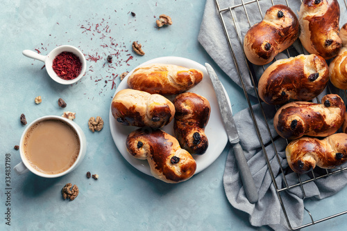 Table brakfast in the morning with plate of fresh yeast buns with saffron and cup of coffee. Homemade food on culinary background. Bake goods. Top view. photo