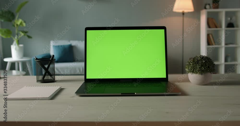 Modern laptop with mock up chroma key green screen on table of living room, desk set up for work at home - technology concept close up zoom 4k video template Modern laptop with mock up chroma key green screen on table of living room, desk set up for work at home - technology concept close up zoom 4k video template
