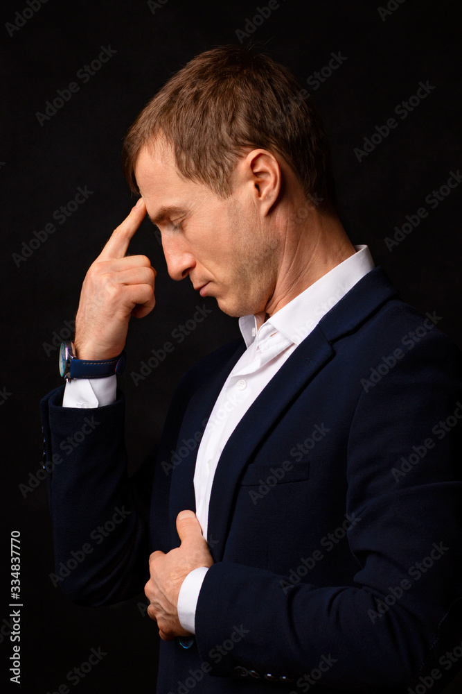 Closeup portrait businessman young man put his finger to his forehead, thinking about the fall of the stock market in New York. Closeup portrait businessman young man put his finger to his forehead, thinking about the fall of the stock market in New York.