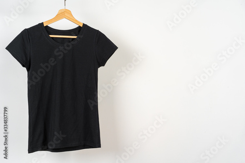 Black plain t-shirt hanging on a hanger, copy space