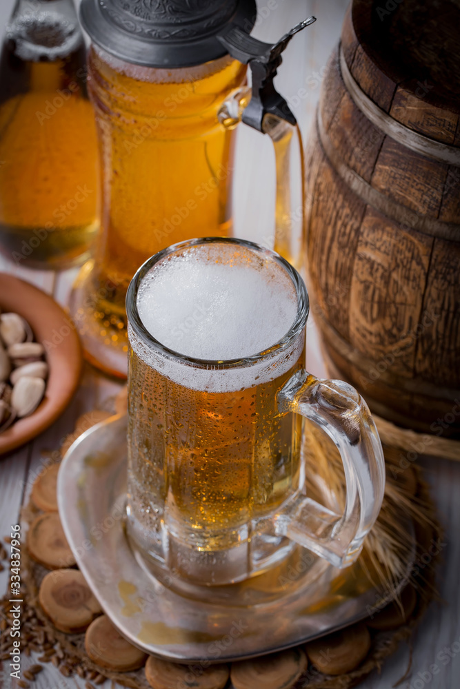 Light frothing beer in a glass, on an old background. Light frothing beer in a glass, on an old background.
