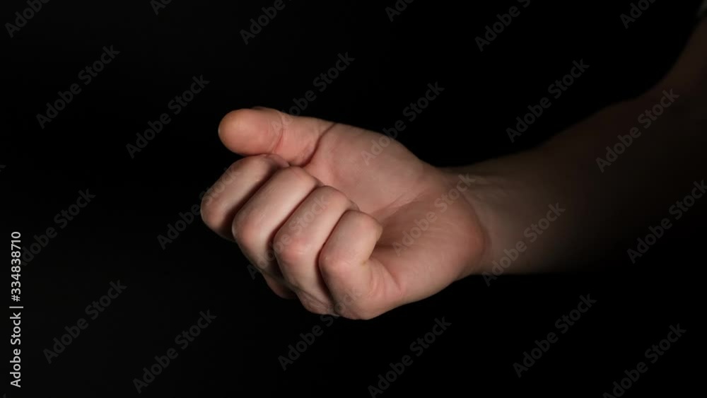 Human male palm clench a fist isolated on black background. Close up.