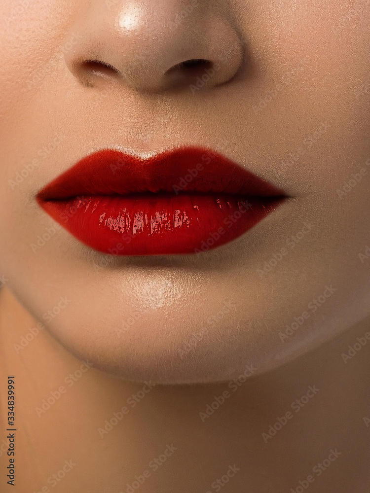 Fototapeta premium Sexual full lips. Natural gloss of lips and woman's skin. The mouth is closed. Increase in lips, cosmetology. red lipstick. Open mouth and with teeth. blonde hair.