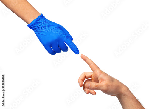 Male and female hands in medical gloves stretch to each other. Help concept. Close up