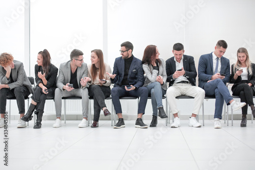 group of diverse young business people looking at their smartphone screens. © ASDF
