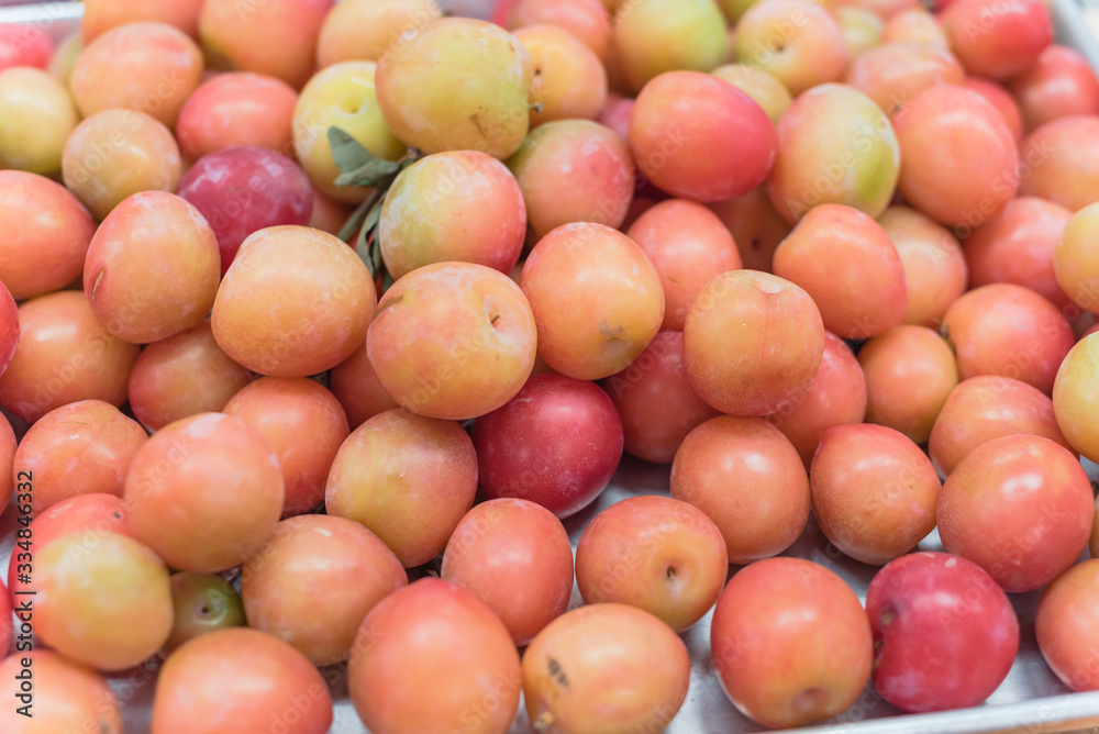 Heap of wild plum in aluminum tray display at local fruit market stand in Texas, USA Heap of wild plum in aluminum tray display at local fruit market stand in Texas, USA