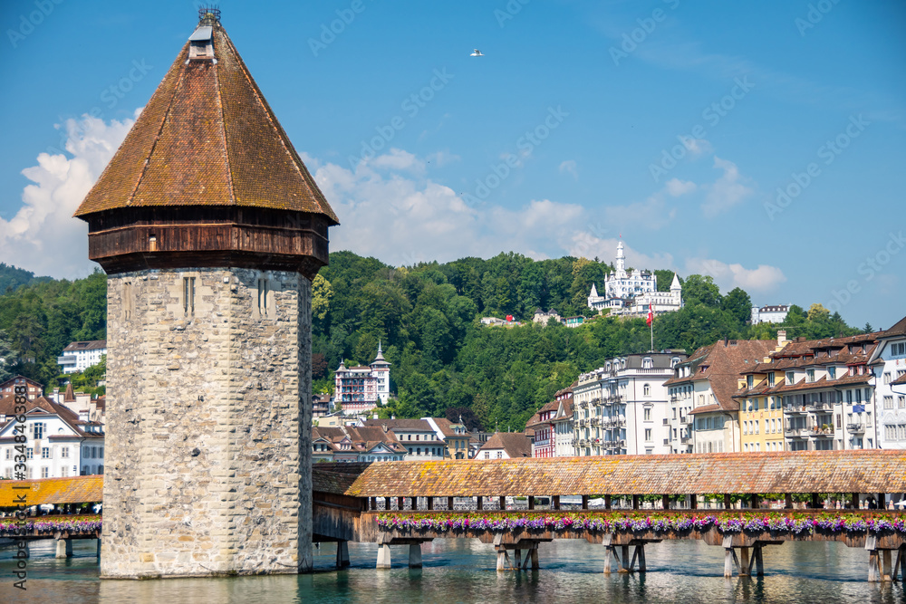 Obraz premium Famous Chapel Bridge, the city's symbol and one of the Switzerland's main tourist attractions on sunny summer day, Switzerland. Historic city center of Lucerne
