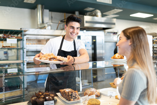 Baker offering bread to customer