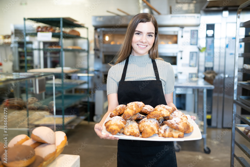 Worker selling pastries in bakery shop Worker selling pastries in bakery shop