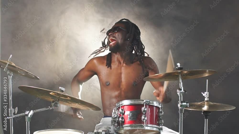 Portrait of african man performing music with use of drum set, handsome black naked man