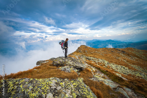 Hiking trough epic mountain landscape with a big backpack, exploring and feeling the freedom of nature