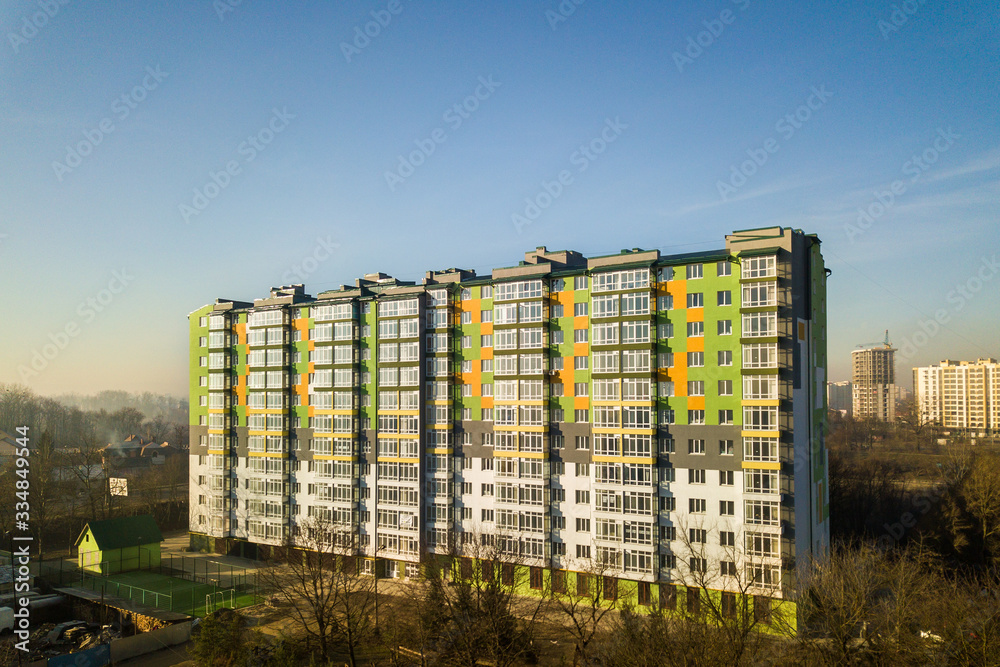 Aerial view of a tall residential apartment building with many windows and balconies. Aerial view of a tall residential apartment building with many windows and balconies.