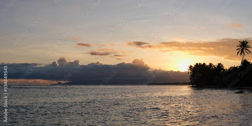 Panorama d’un magnifique coucher de soleil tropical coloré sur une plage de sable fin bordée de cocotiers en Guadeloupe dans les Antilles françaises 