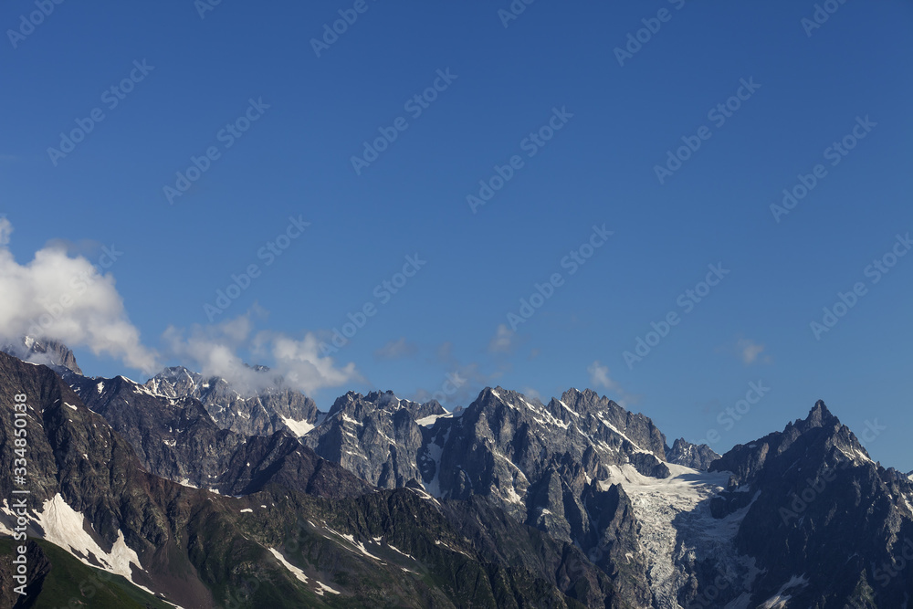 Fototapeta premium Sunlit high mountains with snow and glacier