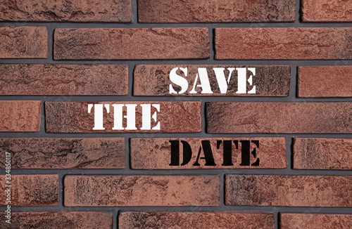 Phrase SAVE THE DATE on brick wall