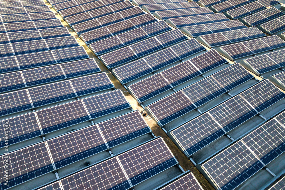 Aerial view of many photo voltaic solar panels mounted of industrial building roof. Aerial view of many photo voltaic solar panels mounted of industrial building roof.