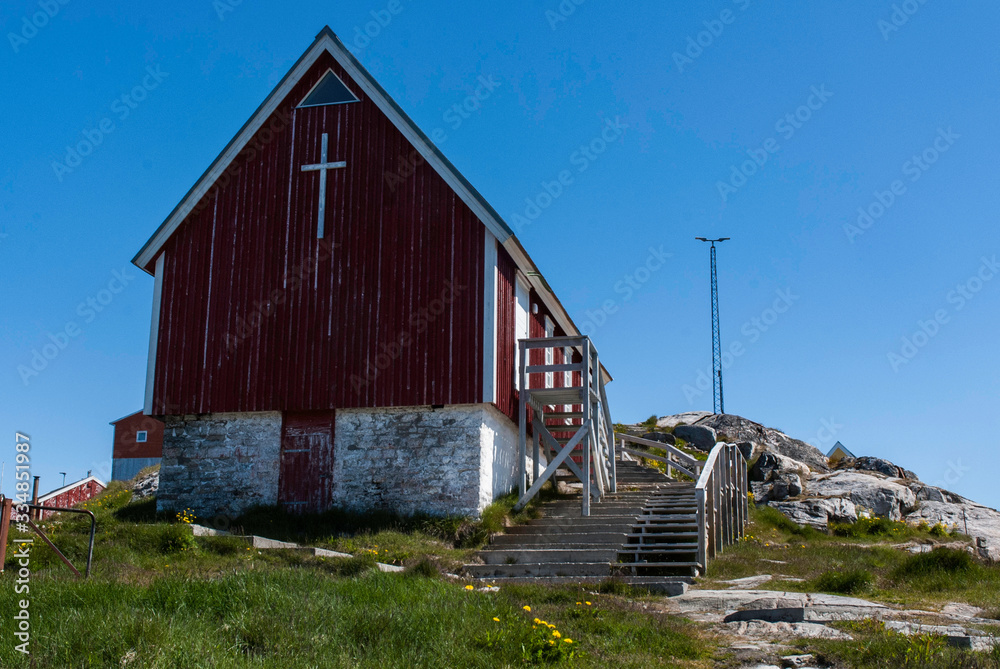 Red church of the fishing town in Greenland. Blue sky in the background.