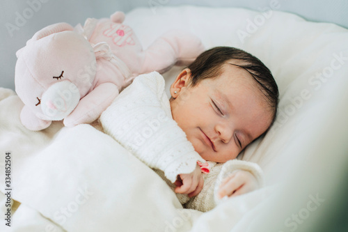 baby in the crib with stuffed toy