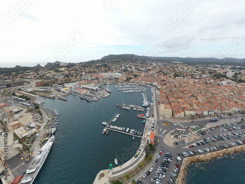 Aerial view of sea dry dock in La Ciotat city  France  the cargo crane  boats on repair  a luxury sail yacht and motor yacht  mountain is on background  shipyard