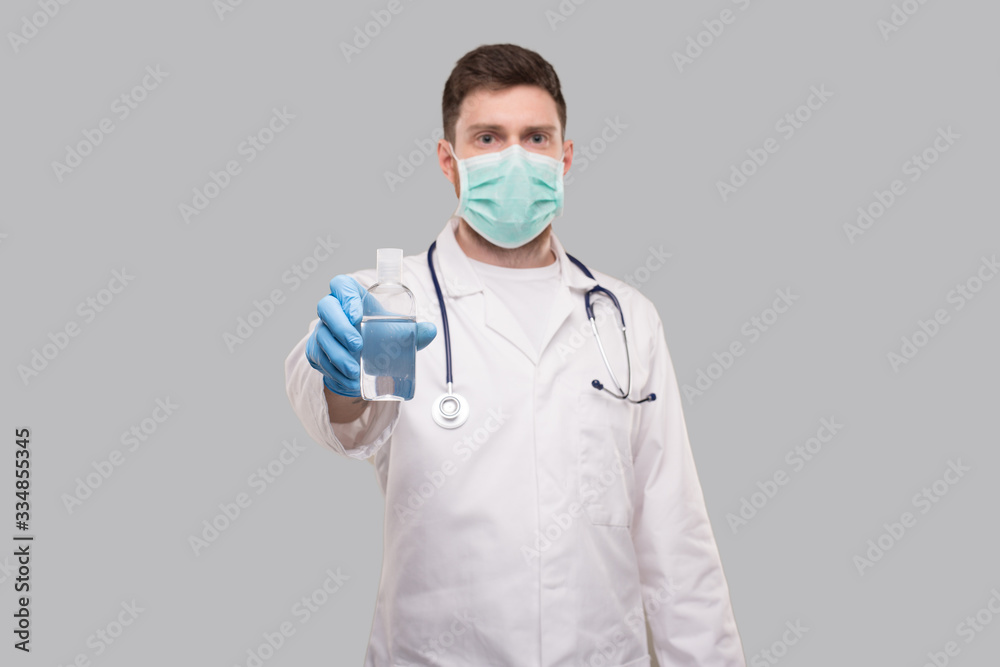Man Doctor Showing Hands Sanitizer Wearing Medical Mask. Hands Wash Antiseptic. Corona Virus Concept Man Doctor Showing Hands Sanitizer Wearing Medical Mask. Hands Wash Antiseptic. Corona Virus Concept