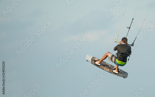 Kiteboarder or kite surfer. Man performing kitesurfing kiteboarding tricks.