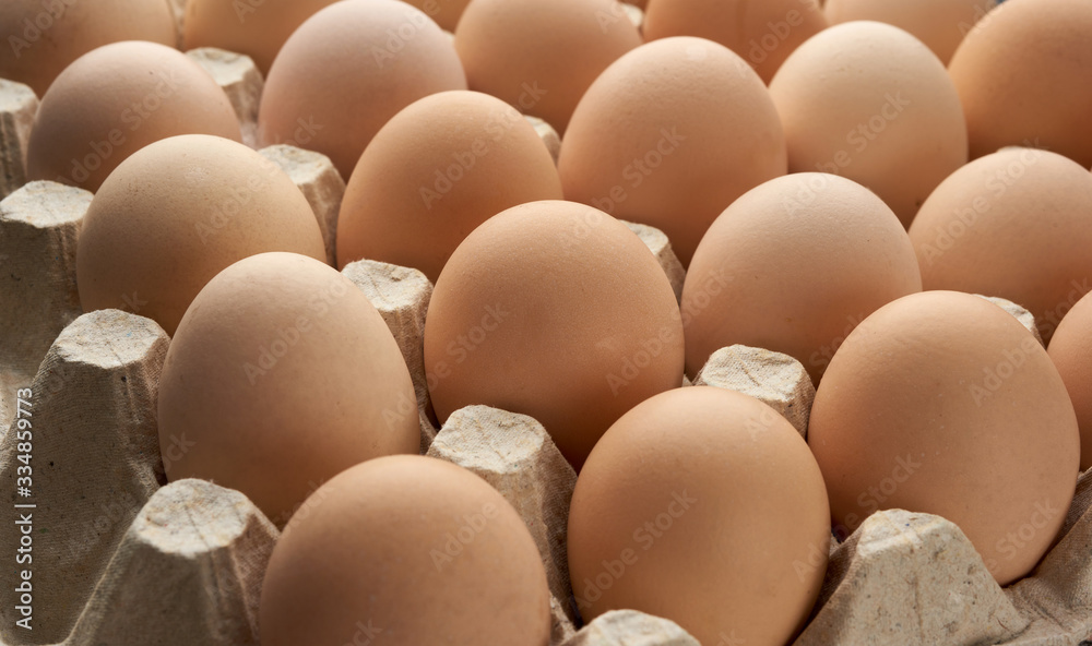 whole round raw brown homemade chicken eggs in a paper tray, selective focus whole round raw brown homemade chicken eggs in a paper tray, selective focus