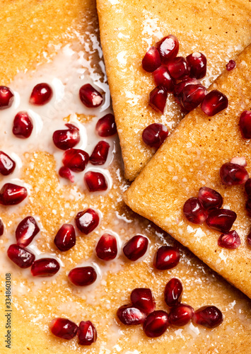 Pancakes with pomegranate and condensed milk. Macro. Top view.