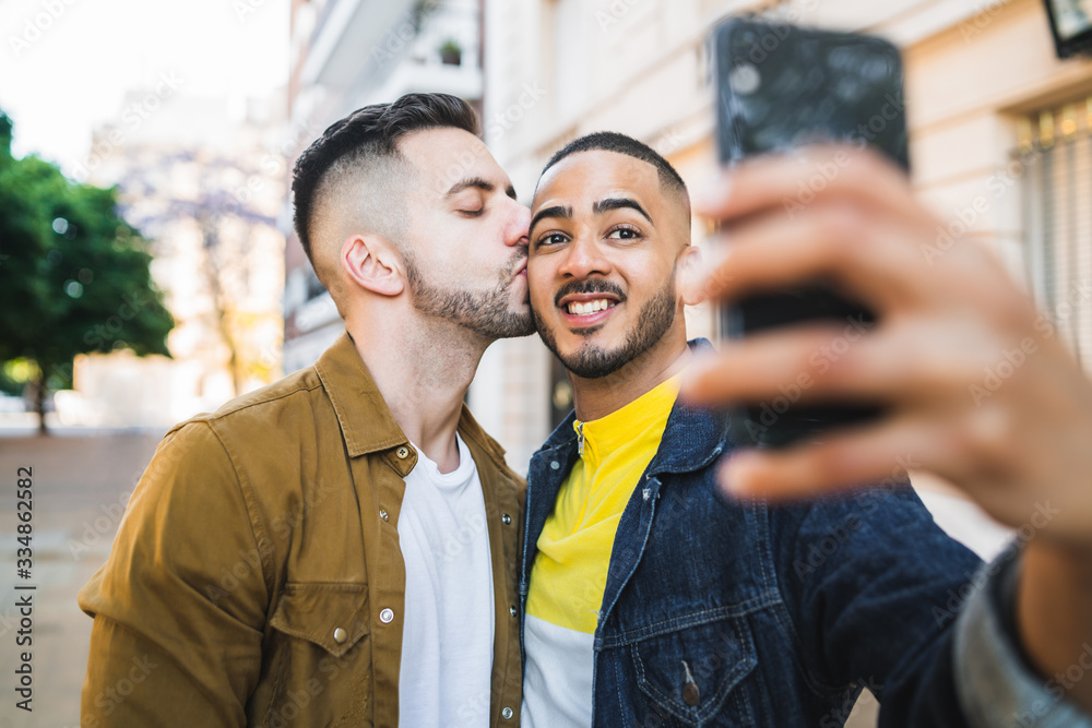 Gay couple taking a selfie in the street. Gay couple taking a selfie in the street.