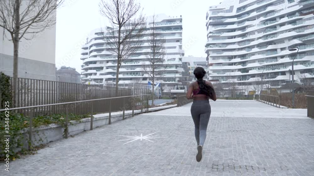 Slow motion shot of sporty young woman jogging in the city Slow motion shot of sporty young woman jogging in the city