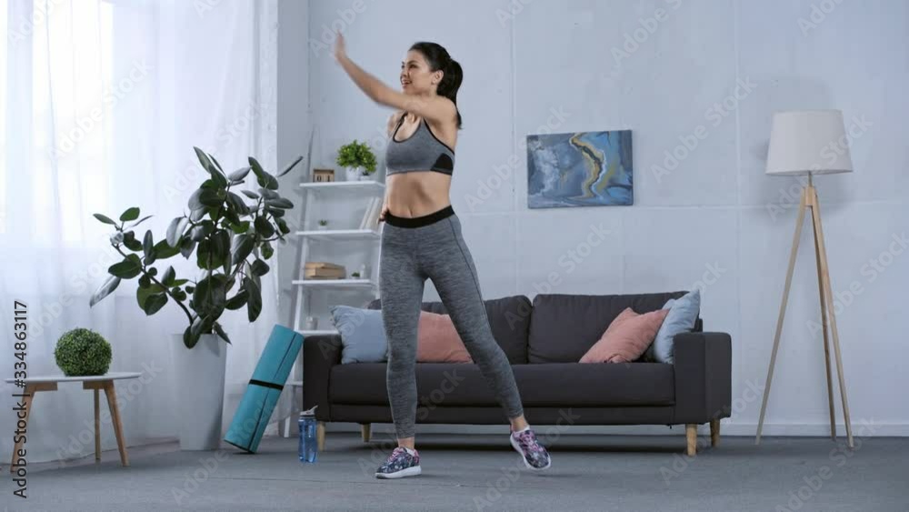 Beautiful smiling sportswoman training at home Beautiful smiling sportswoman training at home